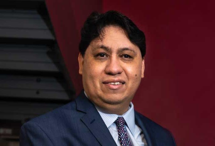 Joe Quintanilla photographed in the pressroom at National Braille Press